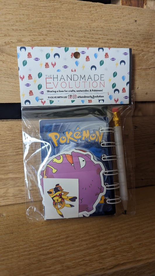 Pokémon card notebooks are packaged with a pencil, two random stickers, and two random temporary tattoos.