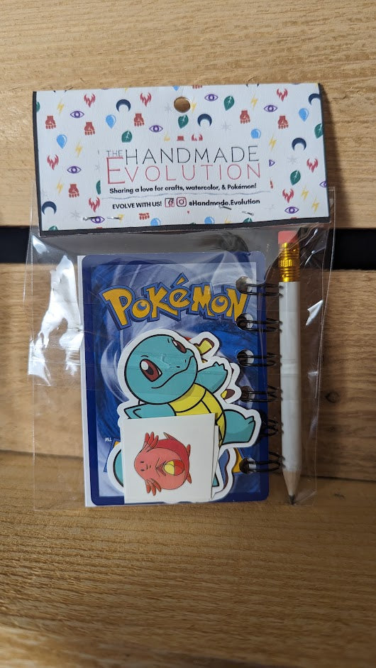 Pokémon card notebooks are packaged with a pencil, two random stickers, and two random temporary tattoos.