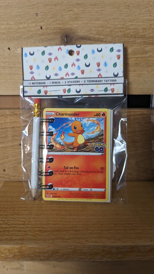 Pokémon card notebooks are packaged with a pencil, two random stickers, and two random temporary tattoos.