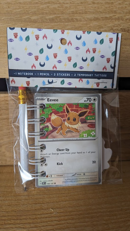 Pokémon card notebooks are packaged with a pencil, two random stickers, and two random temporary tattoos.