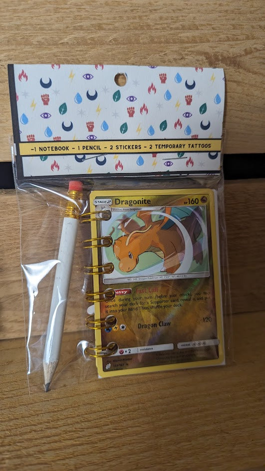 Pokémon card notebooks are packaged with a pencil, two random stickers, and two random temporary tattoos.