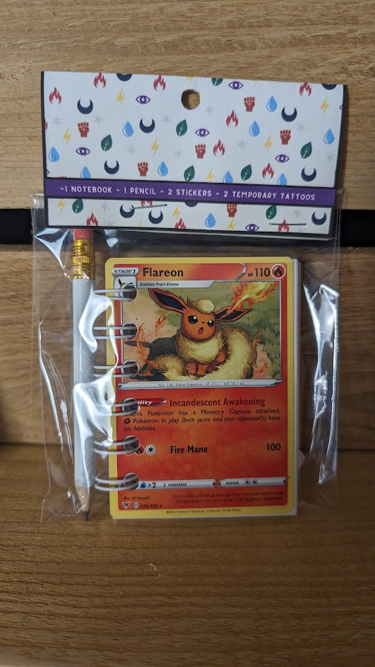 Pokémon card notebooks are packaged with a pencil, two random stickers, and two random temporary tattoos.