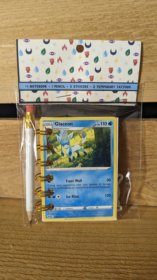 Pokémon card notebooks are packaged with a pencil, two random stickers, and two random temporary tattoos.