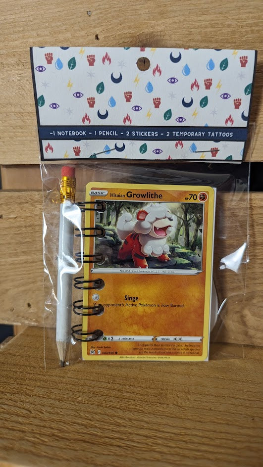 Pokémon card notebooks are packaged with a pencil, two random stickers, and two random temporary tattoos.