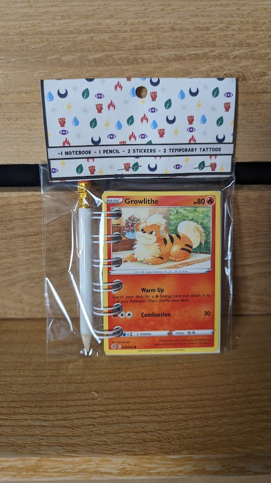 Pokémon card notebooks are packaged with a pencil, two random stickers, and two random temporary tattoos.