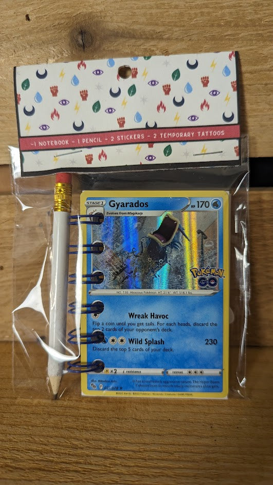 Pokémon card notebooks are packaged with a pencil, two random stickers, and two random temporary tattoos.