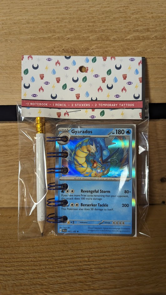 Pokémon card notebooks are packaged with a pencil, two random stickers, and two random temporary tattoos.