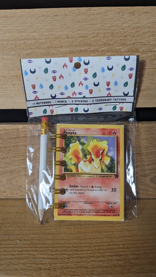 Pokémon card notebooks are packaged with a pencil, two random stickers, and two random temporary tattoos.