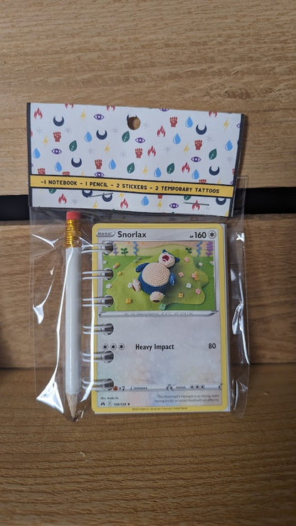 Pokémon card notebooks are packaged with a pencil, two random stickers, and two random temporary tattoos.