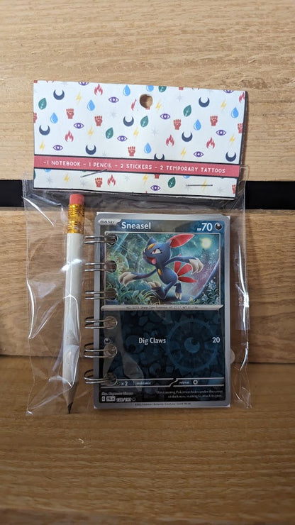 Pokémon card notebooks are packaged with a pencil, two random stickers, and two random temporary tattoos.