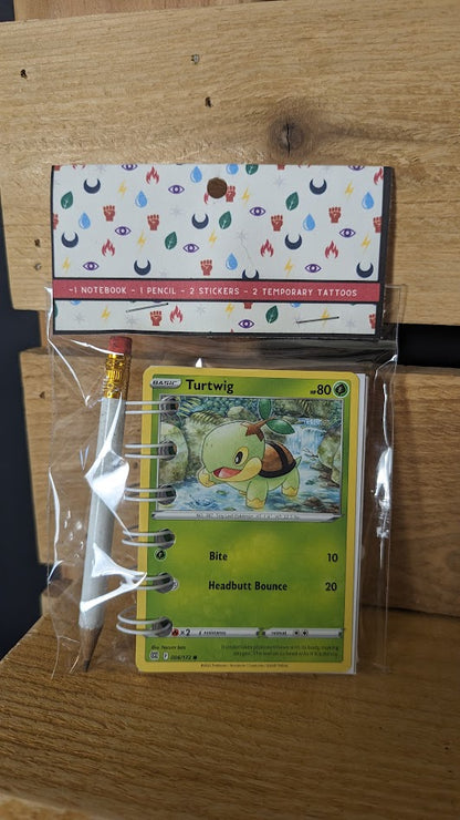 Pokémon card notebooks are packaged with a pencil, two random stickers, and two random temporary tattoos.