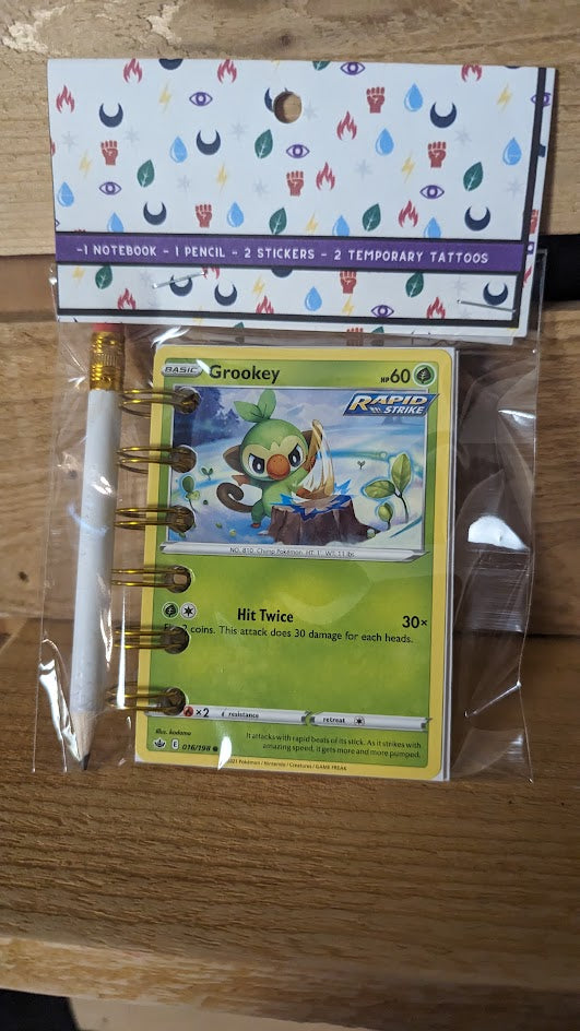 Pokémon card notebooks are packaged with a pencil, two random stickers, and two random temporary tattoos.