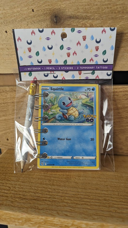 Pokémon card notebooks are packaged with a pencil, two random stickers, and two random temporary tattoos.