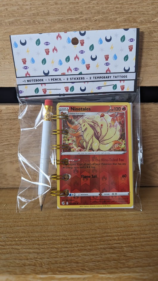 Pokémon card notebooks are packaged with a pencil, two random stickers, and two random temporary tattoos.