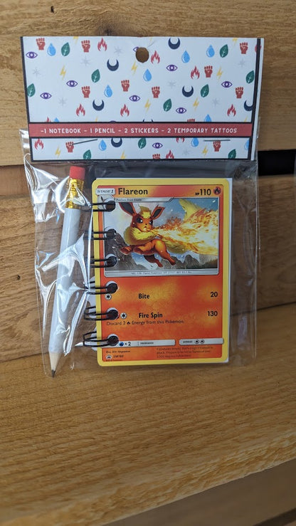 Pokémon card notebooks are packaged with a pencil, two random stickers, and two random temporary tattoos.