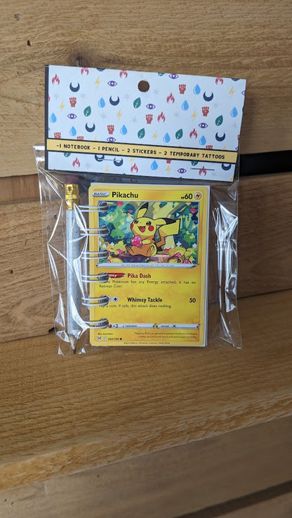 Pokémon card notebooks are packaged with a pencil, two random stickers, and two random temporary tattoos.