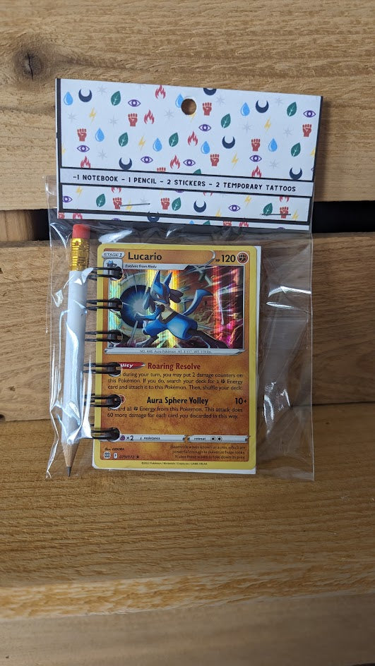 Pokémon card notebooks are packaged with a pencil, two random stickers, and two random temporary tattoos.