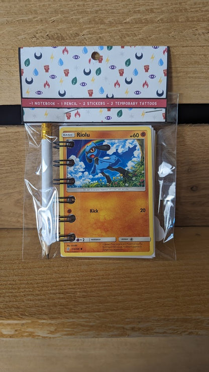 Pokémon card notebooks are packaged with a pencil, two random stickers, and two random temporary tattoos.