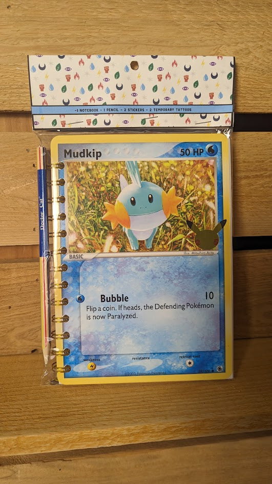 Pokémon card notebooks are packaged with a pencil, two random stickers, and two random temporary tattoos.