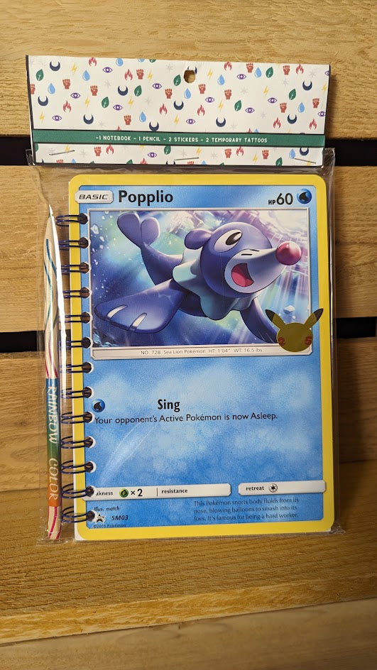 Pokémon card notebooks are packaged with a pencil, two random stickers, and two random temporary tattoos.