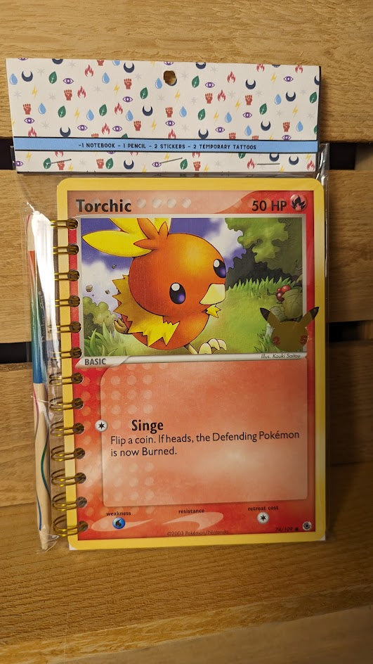 Pokémon card notebooks are packaged with a pencil, two random stickers, and two random temporary tattoos.